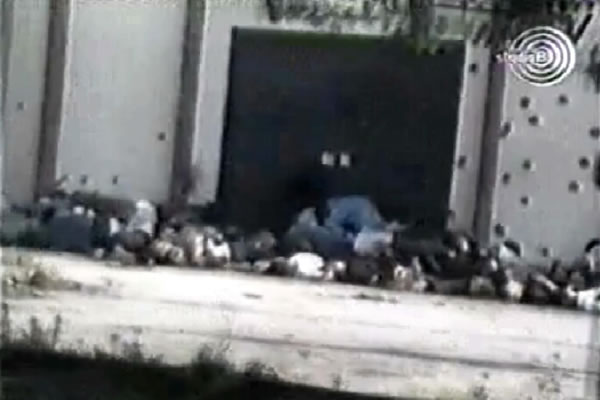Snimak snimljen pred skladištem u Kravici, na kojem se vidi gomila od dvadesetak leševa
